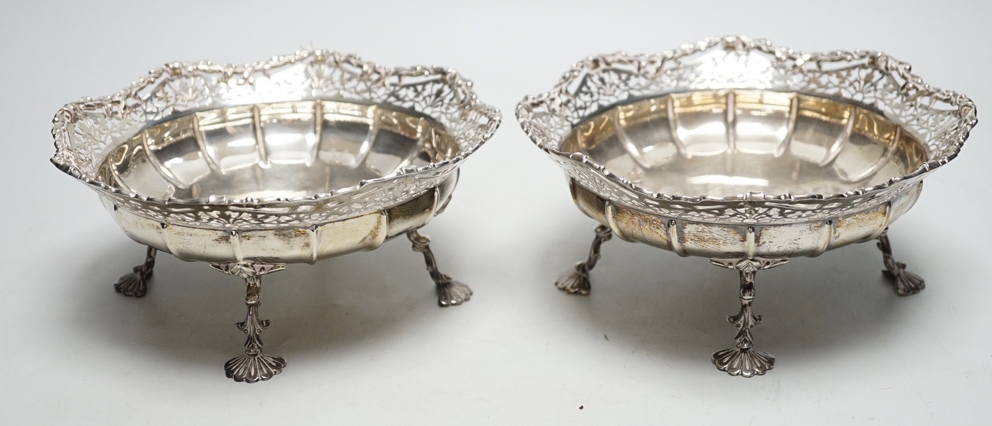 A pair of George VI pierced silver fruit bowls, on quadruped supports, with shell feet, James Ramsay, Birmingham, 1946, diameter 19.2cm, 29.7oz.